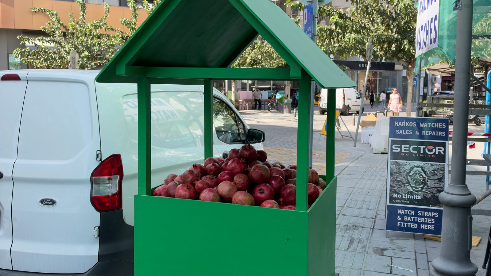 Ripe pomegranates piled in a green wooden street stand in Larnaca, Cyprus