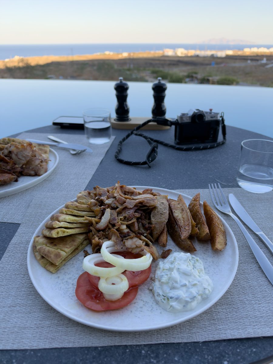 Gyros plate with pita, potato wedges and tzatziki by the infinity pool at Magma Resort Santorini