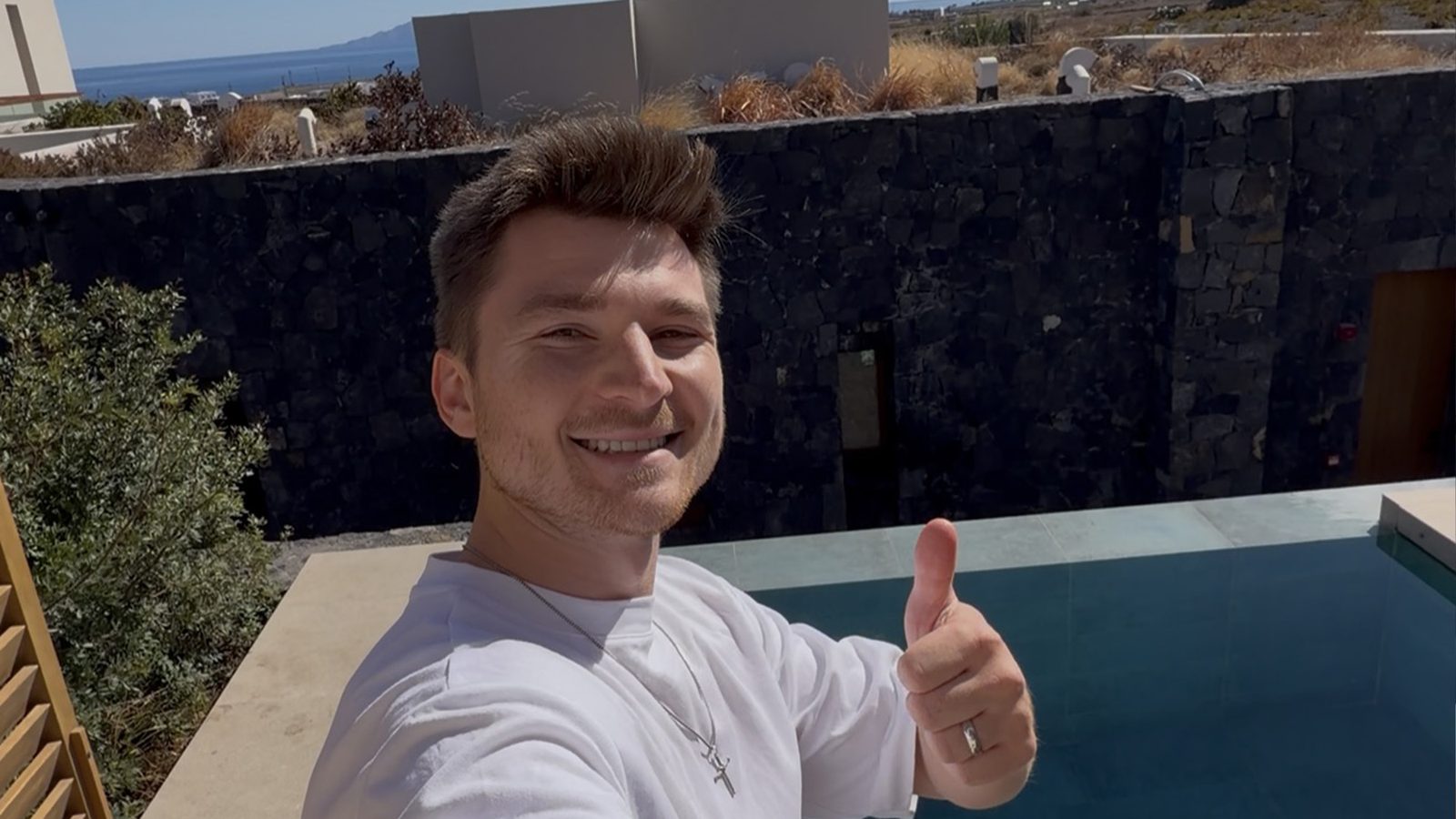 Alex giving a thumbs up by the private hot tub at Magma Resort Santorini