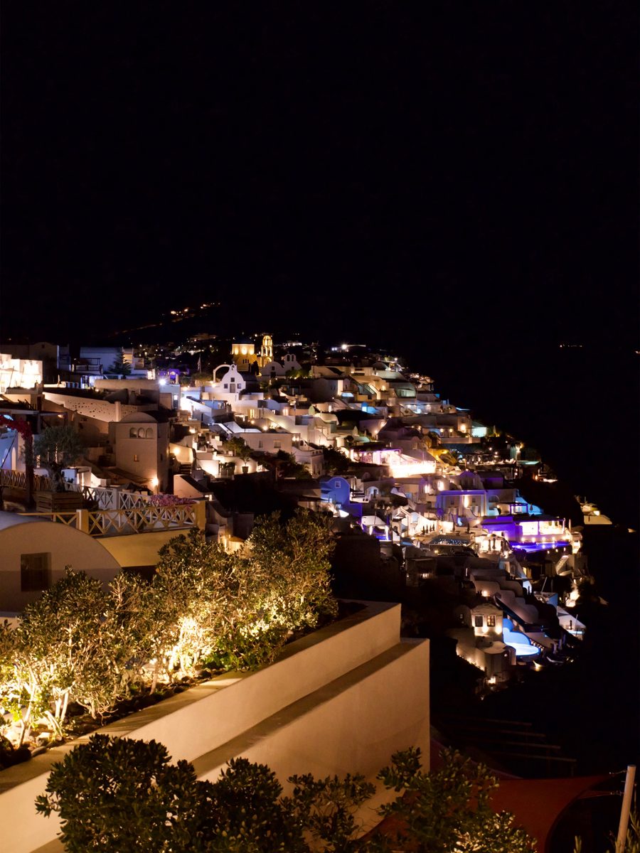 Oia lit up at night along the caldera cliff in Santorini
