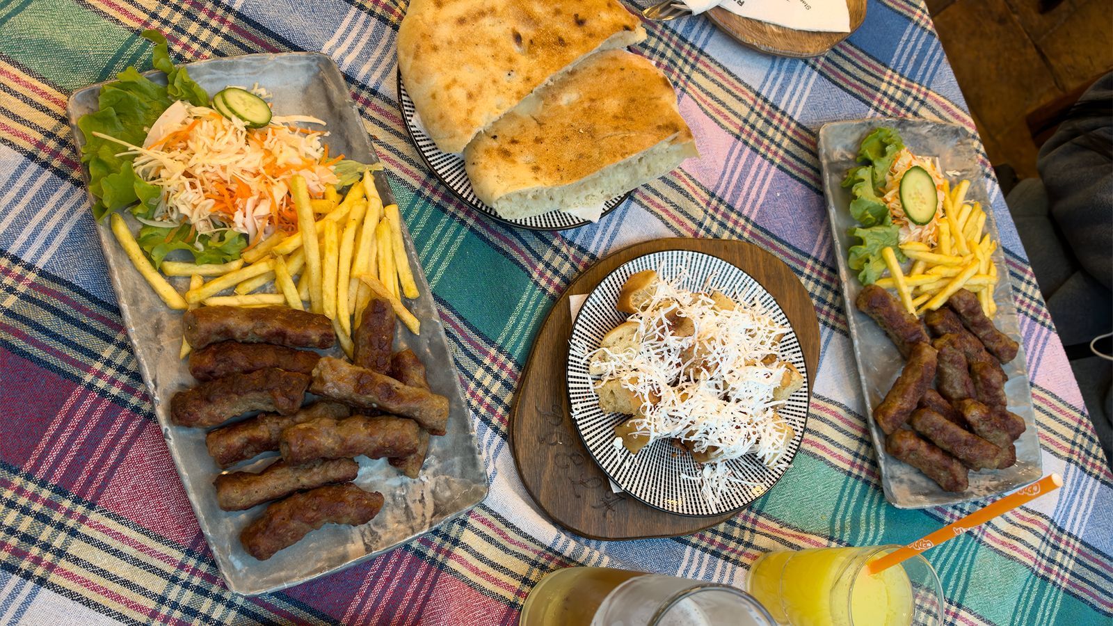 Two kebab plates with fries and salad, fresh bread, bread with cheese, a Skopsko beer and juice at BBQ Pcela in the Old Bazaar, Skopje