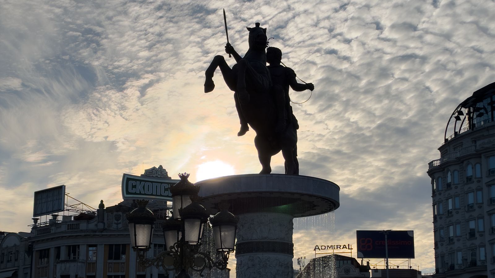Silhouette of the Warrior on a Horse statue and fountain at sunset in Macedonia Square, Skopje